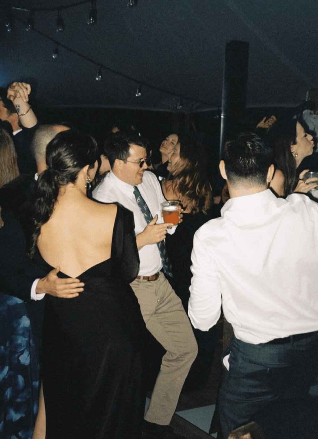 Lior dancing at a wedding, drink in hand